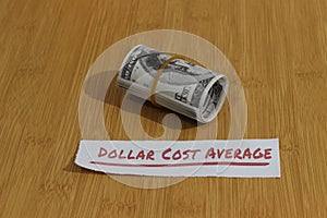 Conceptual Photo, money paper tight by Rubber Band and text Dollar Cost Average, or DCA golden rule investment