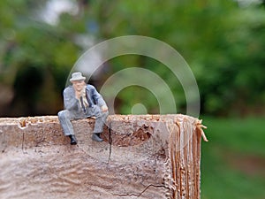 Conceptual Photo, Sad Sitting Man at Bamboo Pole in the park