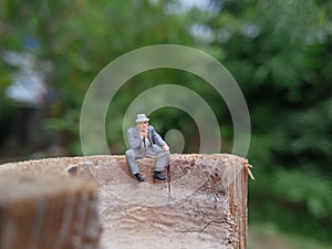 Conceptual Photo, Sad Sitting Man at Bamboo Pole in the park
