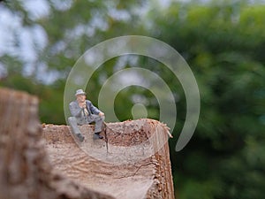 Conceptual Photo, Sad Sitting Man at Bamboo Pole in the park