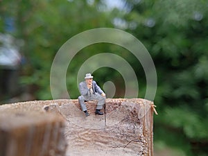 Conceptual Photo, Sad Sitting Man at Bamboo Pole in the park