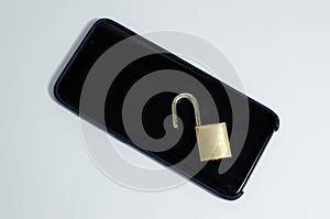 Conceptual photo security on mobile phones. A open padlock on a cell phone on a white background