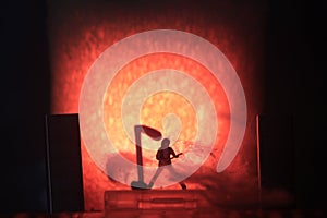 Conceptual Photo, Silhouette Bassist or Guitarist in Action, at Fake Stage, Red Lighting