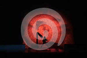 Conceptual Photo, Silhouette Bassist or Guitarist in Action, at Fake Stage, Red Lighting