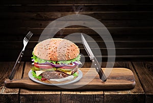 Conceptual photo of typical desired tasty hot homemade burger or cheeseburger on wood table