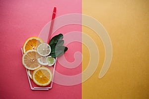 Conceptual photography. Citrus lemonade or juice from fresh fruits in a glass of tubules