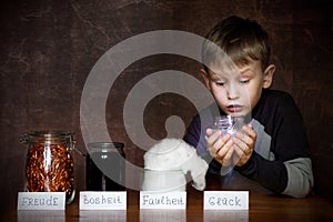 European appearance boy. In jars next to him joy, anger, laziness. In the hands of a child a jar of happiness