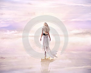 Conceptual picture of a blond lady walking on the delicate, fluffy clouds