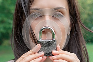 Conceptual portrait of a woman keeping silence with lock over her mouth. caucasian woman keep mouth locked. Language barrier