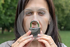 Conceptual portrait of a woman keeping silence with lock over her mouth. caucasian woman keep mouth locked. Language barrier