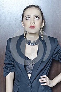 Conceptual portrait of a young, seductive, emotional, beautiful girl, a woman in a black jacket, standing at the door in a hotel