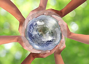 Conceptual symbol of multiracial human hands surrounding the Earth globe. Unity, world peace, humanity concept