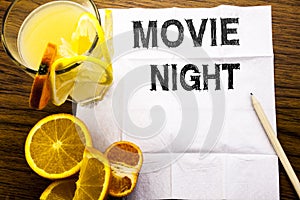 Conceptual text caption showing Movie Night. Concept for Wathing Movies written on tissue paper on the wooden background with pen