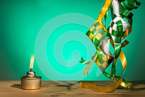 Conceptual traditional Malay oil lamp named pelita with decorative ketupat for Hari Raya Aidilfitri celebration photo