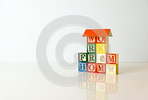 Conceptual of work from home during lockdown directives during virus outbreak. Wooden alphabet cubes forming WORKFROMHOME. Focus