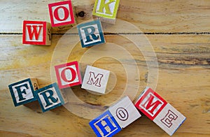 Conceptual of work from home during lockdown directives during virus outbreak. Wooden alphabet cubes forming WORKFROMHOME. Focus