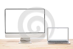 Conceptual workspace or business concept. Laptop computer and big computer monitor display with blank white screens on light