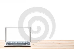 Conceptual workspace or business concept. Laptop computer with blank white screen on light wooden table. Isolated background.