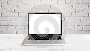 Conceptual workspace, Laptop computer with blank white screen. Mock up laptop on wood table and white brick wall. photo