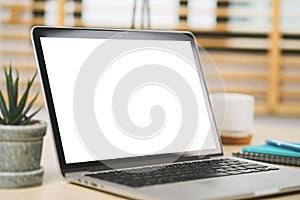 Conceptual workspace, Laptop computer with blank white screen on table.