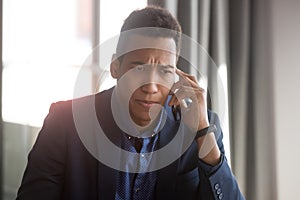 Concerned african American businessman have unpleasant cellphone talk