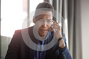 Concerned african American businessman have unpleasant cellphone talk photo