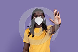 Concerned african american man with protective mask showing stop gesture