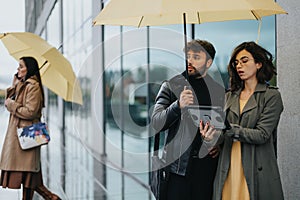 Concerned couple with yellow umbrella looking for directions on tablet on rainy day.