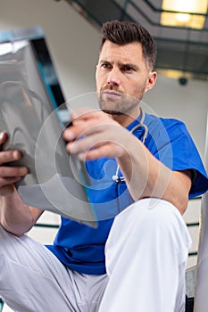 concerned doctor sits and analyses xrays photo