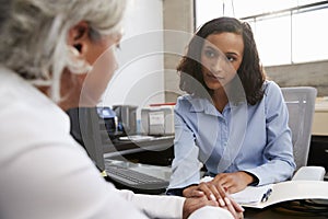 Concerned female analyst counselling senior patient photo