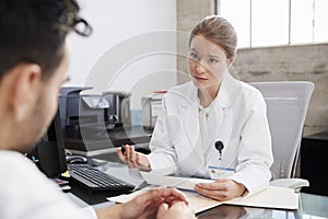 Concerned female doctor in consultation with male patient