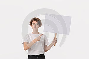 Concerned female protester holding empty signboard with copy space. photo