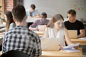 Concerned female reading paper report in coworking space