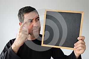 Concerned man looks at an empty blackboard