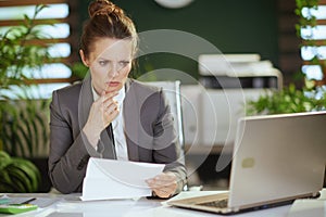 concerned modern woman employee in modern green office