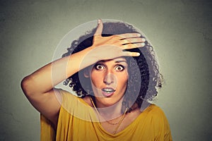 Concerned scared woman with hand on forehead gesture