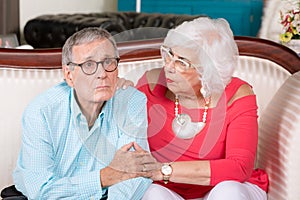 Concerned Senior Man on Couch with Supportive Partner