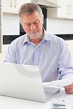 Concerned Senior Man Looking At Finances On Laptop