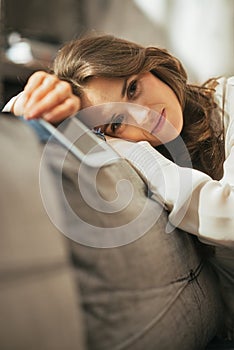 Concerned woman with cell phone sitting on couch