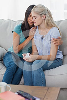 Concerned woman comforting and hugging her sad friend