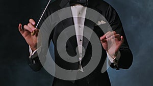 Concert of classical music under direction of an orchestra conductor. Man waves his baton to synchronize and conducting