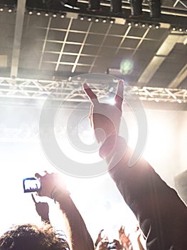 Concert hall with people clapping a band stage