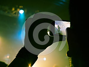 Concert hall with people clapping a band stage