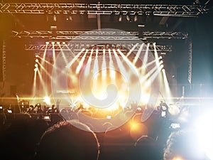 Concert hall with people clapping a band stage