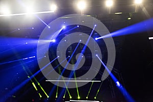 Concert lights, stage, show and excitement.  Light spots in concert, outdoor stage at night, foggy electricity.