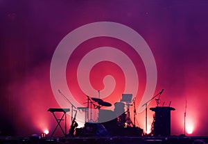 Concert stage on rock festival, music instruments silhouettes, drums and microphones