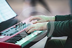 Concert view of a musical keyboard piano player during musical jazz band orchestra performing, keyboardist hands during concert, photo
