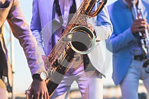 Concert view of saxophonist in a blue and white suit, a saxophone sax player with vocalist and musical band during jazz orchestra