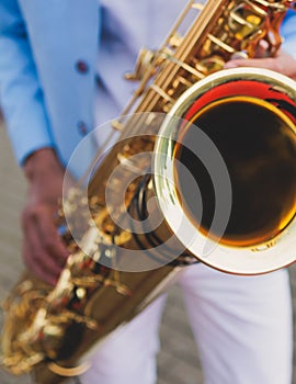 Concert view of saxophonist in a blue and white suit, a saxophone sax player with vocalist and musical band during jazz orchestra