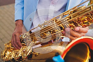 Concert view of saxophonist in a blue and white suit, a saxophone sax player with vocalist and musical band during jazz orchestra